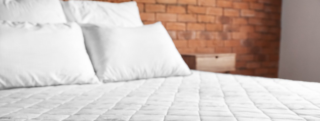 Bett mit bequemer orthopädischer Matratze im Zimmer