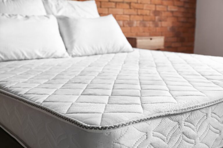 Bett mit bequemer orthopädischer Matratze im Zimmer